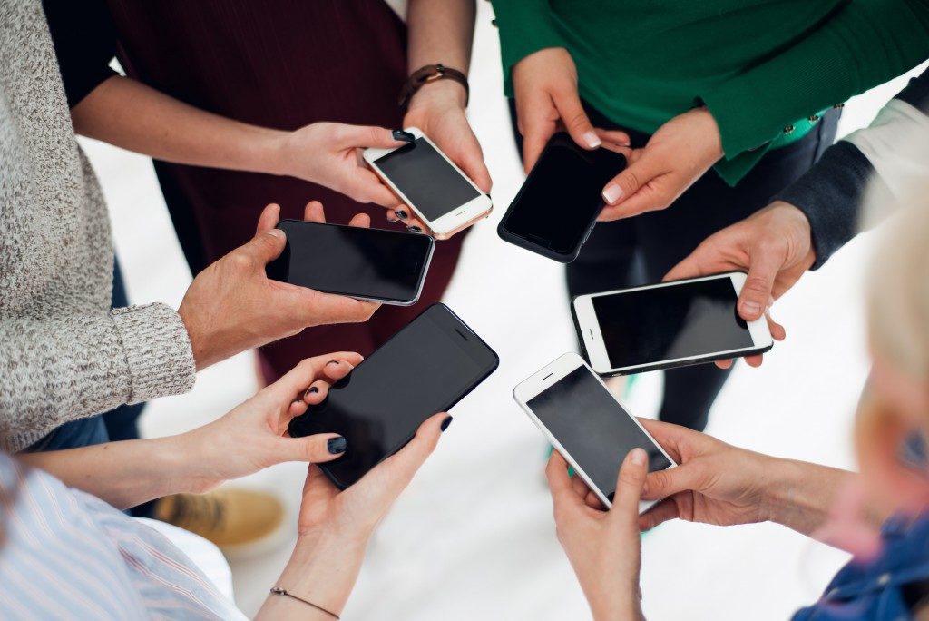 Group of friends using their smartphone